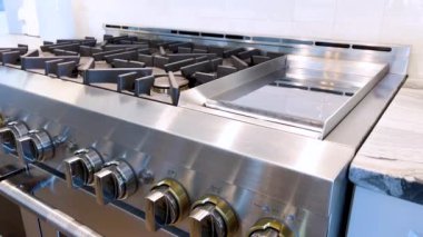 Modern mutfakların yakın plan görüntüsü paslanmaz çelik gaz sobası detaylı düğmeler ve parlak bir geri sıçrama, işlevsellik ve stil karışımı..