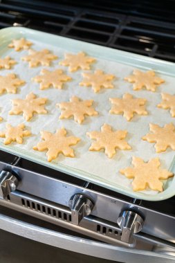 Lezzetli kar tanesi şeklindeki kurabiyeleri pişirdikten sonra soğutarak onları Noel hediyelerine hazırlamak..
