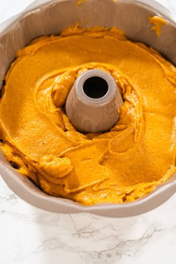 Pasta hamurunu kek tepsisine dökerek nefis bir ev yapımı balkabağı pastası yapmaya hazır..