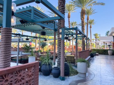 Las Vegas, Nevada, ABD-Kasım 09, 2024 Red Rock Resort 'ta zarif bir açık hava alanı. Uzun, görkemli palmiye ağaçları ve huzur verici bir yansıtıcı havuzu var. Kristal berrak su palmiyeyi yakalar.