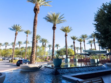 Las Vegas, Nevada, ABD-Kasım 09, 2024 Red Rock Resort 'ta zarif bir açık hava alanı. Uzun, görkemli palmiye ağaçları ve huzur verici bir yansıtıcı havuzu var. Kristal berrak su palmiyeyi yakalar.