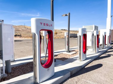 Kunduz, Utah, ABD-10 Kasım 2024, Tesla Supercharger 'a bağlı bir Tesla Cybertruck' ın yakın plan görüntüsü açık arazinin manzaralı arka planına ve parçalı bulutlu gökyüzüne karşı. İnce çizgiler.