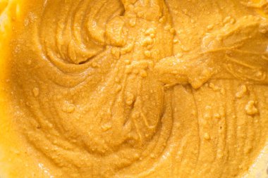 Bardak karıştırma kabında, büyük bir el çırpma ustalıkla lezzetli zencefilli kek ve karamel kremalı pasta malzemelerini karıştırır..