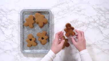 Düz yatıyordu. Zencefilli kurabiyeler, kalp şeklinde kesilmiş zencefilli bir adam, mermer bir tezgahın karşısında kırsal metal bir tepside dinleniyor..