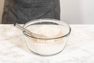 Klasik zencefilli kurabiye hamuru, un, kabartma tozu ve tarçın, zencefil ve karanfil gibi baharatlar içeren kuru malzemeler içeren bir karışım kasesinin göz hizasında görüntüsü. Bu malzemeler...