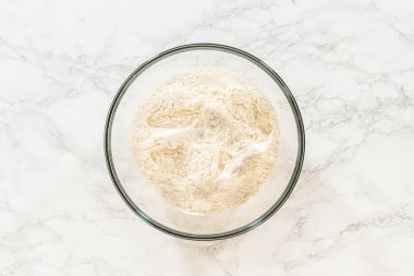 Çikolatalı Zencefilli Kurabiye Hamuru 'nun temeli olarak kullanılmaya hazır bir kase un. Bu un kakao, baharat ve diğer malzemelerle birleşerek yumuşak ve lezzetli bir hamur oluşturacak..