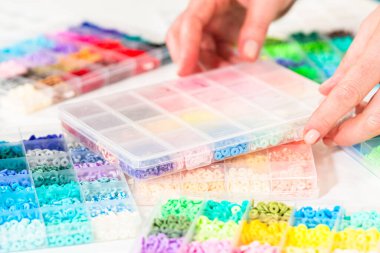 Beyaz bir masaya yerleştirilmiş çeşitli kil boncuk kutuları yaratıcı çocukların el sanatları projesini bekliyor..