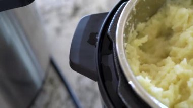 Şık, modern bir mutfakta, hızlı ve lezzetli bir yemek için fırın kullanarak kadifemsi patates püresi hazırlıyor..