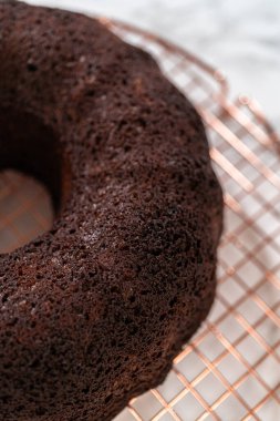 Chocolate Bundt Pastası dikkatlice tavadan çıkartılır. Yuvarlak soğutma rafına yerleştirilir. Kusursuz bir sunum ve hoş bir hoşgörü için hazırlanır..