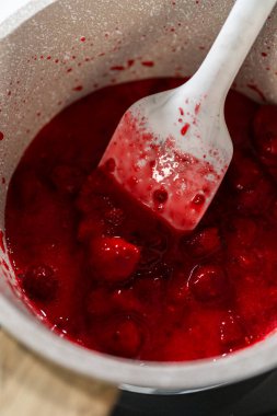 Küçük bir tencerede, ölçülen malzemeler bir araya gelir. Lezzetli ahududu kekinin kaynatılmasına ve lezzetli tatlarla doldurulmasına izin verir..