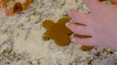 Çağdaş beyaz bir mutfakta zencefilli kurabiye hamuru ustalıkla sarılır ve nefis bir tatil ziyafeti için zemin hazırlar..