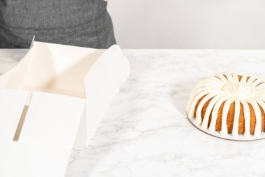 Havuçlu kek dikkatlice paketlenir beyaz bir kağıt bohça pasta kutusu, hediye ya da paylaşım için hazır.