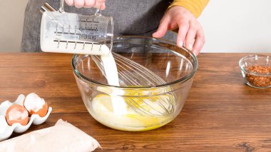 Bardak karıştırma kabında, büyük bir el çırpma ustalıkla lezzetli zencefilli kek ve karamel kremalı pasta malzemelerini karıştırır..