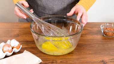 Bardak karıştırma kabında, büyük bir el çırpma ustalıkla lezzetli zencefilli kek ve karamel kremalı pasta malzemelerini karıştırır..