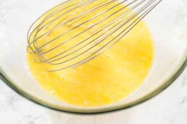 Büyük bir cam kasede, malzemeler harika havuçlu kek pişirmek için ustalıkla karıştırılır..