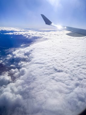 Uçuş sırasında bir uçak penceresinden kaydedilen karla kaplı dağ sıralarının manzaralı görüntüsü. Çarpıcı manzara engebeli tepeleri, vadileri ve yumuşak kış atmosferini gözler önüne seriyor.