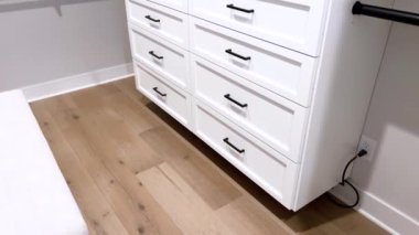 Kıtır beyaz çekmeceler, şık siyah saplarla donatılmış, modern minimalizm ve organizasyonun vizyonunu sunan bu birim. Pürüzsüz yüzeyler ve temiz çizgiler çağdaşlığın bir örneği.
