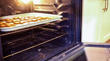 Nefis zencefilli kurabiyeler bir gaz fırınında pişiyor, mutfağı sıcak, aromatik bayram mutluluğuyla dolduruyor..