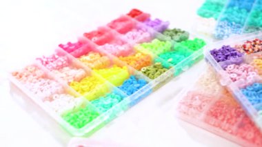 Renklere göre sıralanmış çeşitli kil boncukların yakın plan çekimleri, her boncuğu el yapımı ve mücevher yapımında eşsiz kılan desenleri ve desenleri vurguluyor..