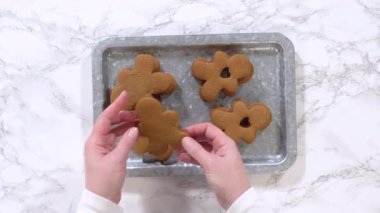 Düz yatıyordu. Zencefilli kurabiyeler, kalp şeklinde kesilmiş zencefilli bir adam, mermer bir tezgahın karşısında kırsal metal bir tepside dinleniyor..