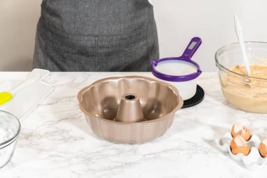 Silikon bir fırça kullanarak, metal demet kek tavası eritilmiş sebze kısaltmasıyla yağlanır, nefis havuçlu kek pişirmeye hazırlanır..