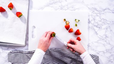 Düz yatıyordu. Lezzetli kırmızı çilekler, bazıları erken bozulmayı gösteriyor, beyaz bir kesme tahtasının üzerine yerleştirilmiş, güvenli bir şekilde tutulmuş, yanında kağıt havlu kaplı cam bir kase,