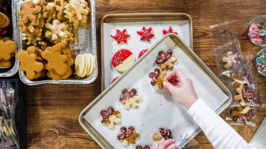Düz yatıyordu. Dikkatlice paketlenmiş Noel kurabiyeleri, çikolataya batırılmış, ezilmiş fındık serpiştirilmiş, ve şeffaf selofan ambalajla sunulmuş..