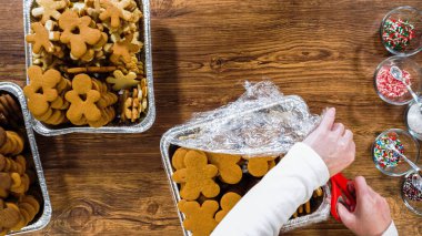 Düz yatıyordu. Noel hediyesi olarak yiyecek süslemek için dondurulmuş zencefilli kurabiye paketleri açıyorum..