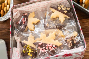 Sevimli ev yapımı zencefilli kurabiye ve şekerli kurabiye, bol çikolataya batırılmış, dekoratif Noel kutusuna yerleştirilmiş mevsimlik hediyeler için mükemmel..