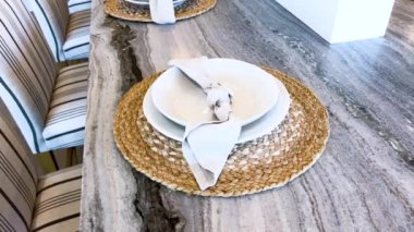 Görüntü, şık çizgili sandalyeleri ve pürüzsüz tabakları olan uzun mermer bir adaya sahip, canlı sulu ve yeşil bir dokunuş ekleyen geniş bir modern mutfak sergiliyor..