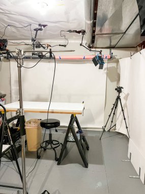 Castle Pines, Colorado ABD - 30 Ocak 2023-A bodrum fotoğrafçılığı veya mermer stili bir masa, ayarlanabilir aydınlatma platformları, monitörler ve tripodlar içeren video stüdyosu. Tamamlanmamış bodrum