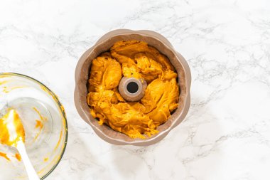 Düz yatıyordu. Pasta hamurunu kek tepsisine dökerek nefis bir ev yapımı balkabağı pastası yapmaya hazır..