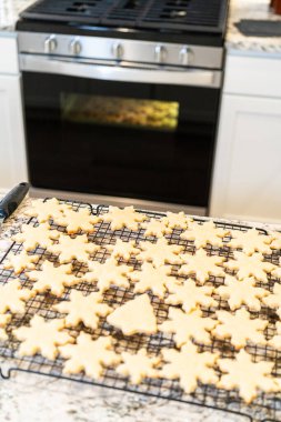 Lezzetli kar tanesi şekilli şekerli kurabiyeleri rafta soğutup onları Noel hediyelerine hazırlıyorum..