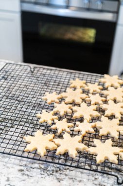 Lezzetli kar tanesi şekilli şekerli kurabiyeleri rafta soğutup onları Noel hediyelerine hazırlıyorum..