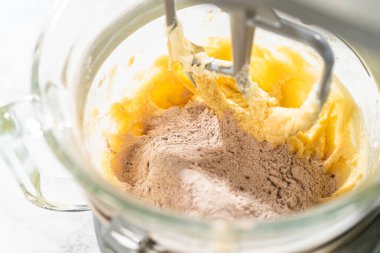 Kuru malzemeler, un ve kakao da dahil, çikolatalı zencefilli, şekerli kurabiye hamuru karışımına eklendi, nihai karışıma hazır..