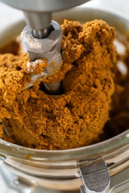 Klasik Zencefilli Kurabiye Hamuru kalın ve iyi karıştırılmış, mikserin küreği pürüzsüz entegrasyon gösteriyor. Hamur zengin, güzel kokulu ve bunları yaratmak için bir sonraki adım için hazır görünüyor.