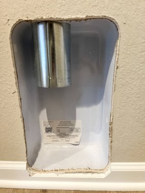 Castle Rock, Colorado, USA-February 11, 2023-Close-up view of a laundry dryer vent outlet in a newly constructed home. The installation includes a metal exhaust pipe and a white recessed wall box clipart