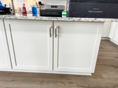 Castle Rock, Colorado, USA-March 16, 2023-Modern kitchen featuring white cabinets with silver handles, granite countertops, and a hexagon tile backsplash. Countertop appliances include an air fryer clipart