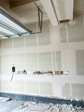 Castle Rock, Colorado, ABD-22 Mart 2023-Residential garaj duvarı altında düzgünce sarmalanmış bir Tesla elektrikli araç şarj aleti var. Alçıpan inşaatı görülebilir