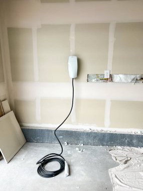 Castle Rock, Colorado, ABD-22 Mart 2023-Residential garaj duvarı altında düzgünce sarmalanmış bir Tesla elektrikli araç şarj aleti var. Alçıpan inşaatı görülebilir