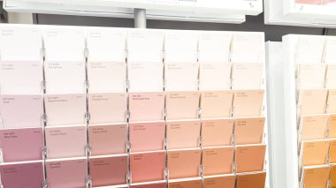 Denver, Colorado, USA-January 13, 2024-Displays of a vibrant wall of paint swatches, ranging from purples to yellows. The swatches are neatly arranged, offering customers a comprehensive visual guide clipart