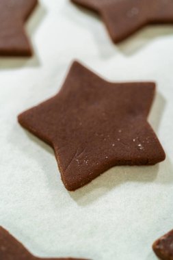 Parşömen kağıdına yerleştirilmiş çiğ çikolatalı kurabiyelerin yakın plan görüntüsü, temiz kenarlarını vurguluyor..