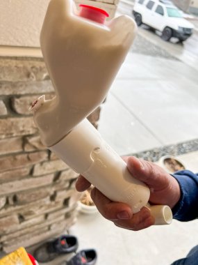 Castle Rock, Colorado, USA-April 26, 2023-A close-up of a person holding a broken wall texturing tool The plastic device appears damaged possibly from improper use or storage The background shows a clipart