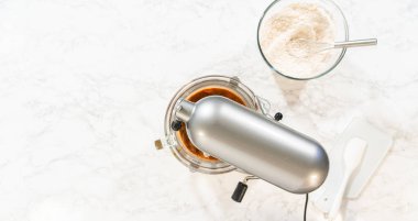 Klasik Zencefilli Kurabiye Hamur Kurabiyesi için temel malzemelerle çevrili bir yemek pişirme seti manzarası. İçindekiler arasında esmer şeker, tereyağı, un karışımı ve koyu pekmez bulunur.