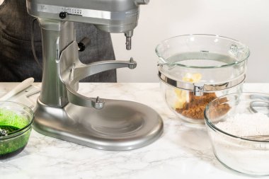 Tereyağlı ve esmer şekerli karıştırıcı, canlı zencefilli kurabiyeler ve Şenlikli Pişirme için temel oluşturmak üzere krema ile birleştiriliyor. Bu basamak, kurabiyeler için yumuşak, yumuşak bir doku yaratır..