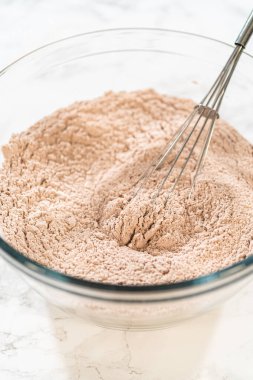 Mixing bowl with dry ingredients for Pale Gingerbread Cookies including flour, cinnamon, cloves, ginger, and nutmeg. Ready for blending. clipart