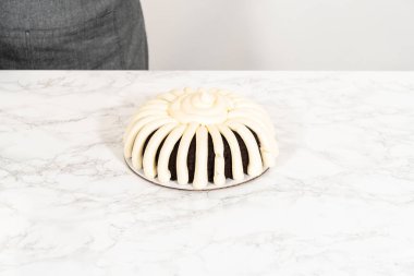 Hassasiyetle, çikolatalı kek dikkatlice tavadan çıkartılır. Lezzetli krem peynirle süslenir ve lezzetli bir ziyafet yaratır..