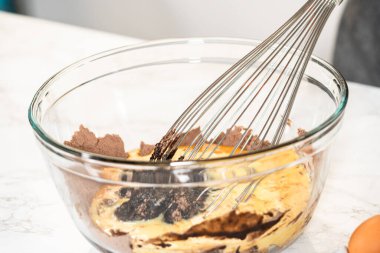 Ağız sulandıran çikolatalı kekler yapma sürecinde ilk adım, mükemmel hamur makinesini yapmak için malzemeleri titizlikle karıştırmayı içerir..