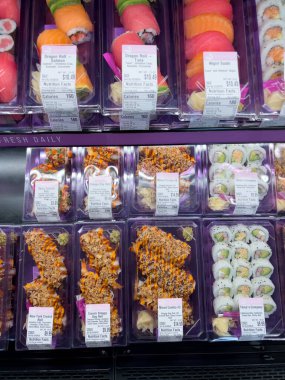 Süpürge, Colorado, ABD-8 Şubat 2025 - Temiz plastik kaplarda paketli taze suşi ruloları bir markette soğutulmuş bölümde sergilenmektedir