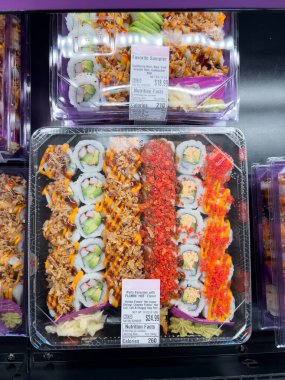 Süpürge, Colorado, ABD-8 Şubat 2025 - Temiz plastik kaplarda paketli taze suşi ruloları bir markette soğutulmuş bölümde sergilenmektedir